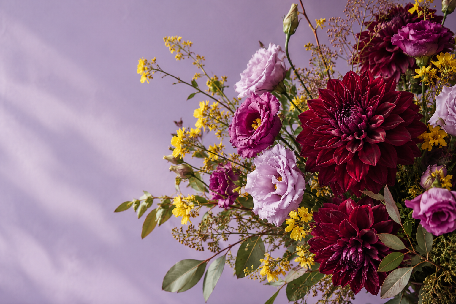 Composição conceitual com flores em tons de bordô, lilás e amarelo